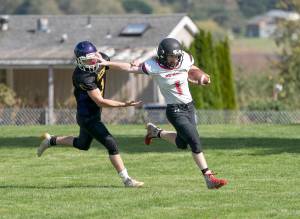 <strong>Steve Mullensky</strong>/for Peninsula Daily News                                Neah Bays Meric Soeneke stiff arms Quilcenes Chase Newman during the Red Devils 60-39 win Saturday in Quilcene.