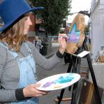 Gianna Andrews, of Vashon Island-based Gianna Andrews Art, paints a new creation at her booth at Saturdays Arts & Draughts Festival in downtown Port Angeles. (Keith Thorpe/Peninsula Daily News)