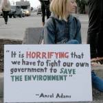 Faith Masimer of Port Angeles sits on a curb near Hollywood Beach in Port Angeles at the start of Fridays Climate Strike. (Keith Thorpe/Peninsula Daily News)