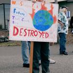 Ewan Mordecai-Smith, 11, a sixth-grade student at Roosevelt School, holds a sign calling for action on climate change at the start of Fridays Climate Strike rally in Port Angeles. (Keith Thorpe/Peninsula Daily News)