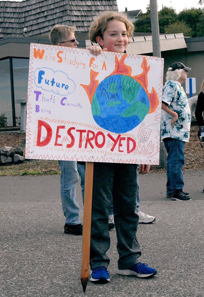 Ewan Mordecai-Smith, 11, a sixth-grade student at Roosevelt School, holds a sign calling for action on climate change at the start of Fridays Climate Strike rally in Port Angeles. (Keith Thorpe/Peninsula Daily News)