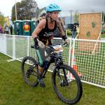 Eliza Winne of the Upper Left Crossfit Sirens team of Sequim finishes the mountain bike leg of the 2018 Big Hurt on Saturday at the West End Park on the Port Angeles waterfront. (Keith Thorpe/Peninsula Daily News)