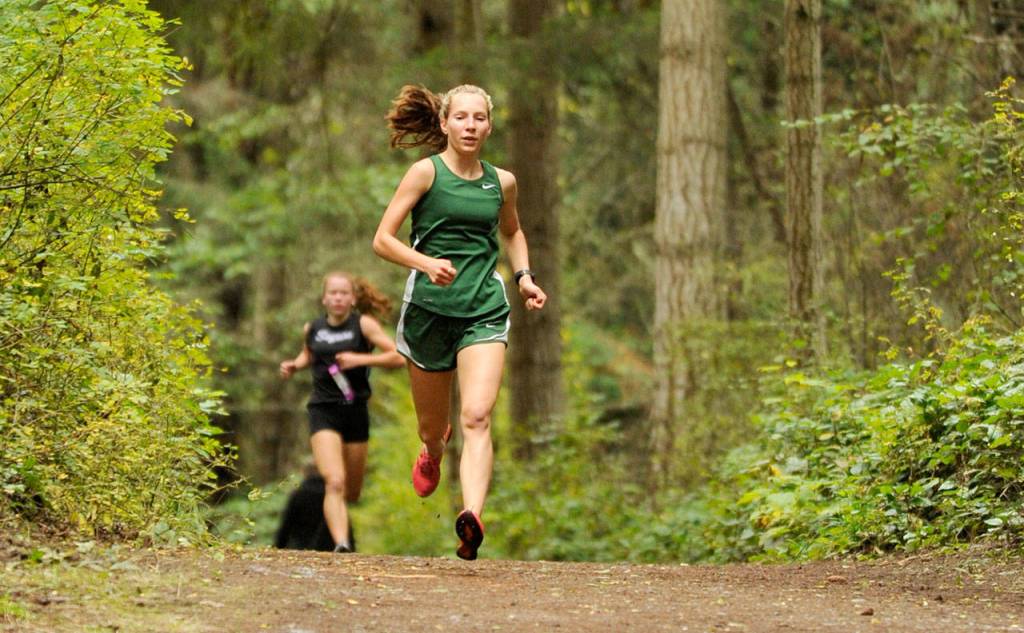 Michael Dashiell/Olympic Peninsula News Group Port Angeles Lauren Larson runs ahead of Sequims Riley Pyeatt during a girls cross country meet Wednesday at Robin Hill County Park.