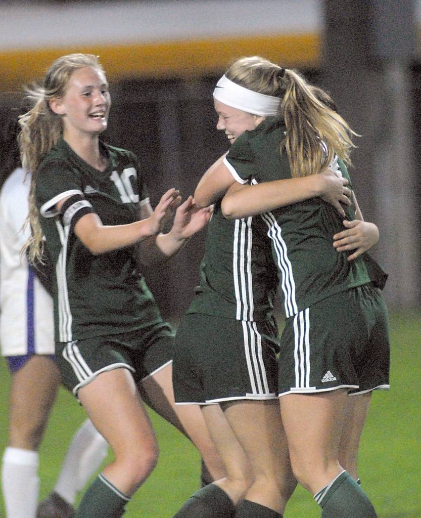 Keith Thorpe/Peninsula Daily News Port Angeles Anna Petty, right, receives a hug from teammate Bailee Larson and congratulations from Millie Long after scoring a goal in the first half on Thursday against North Kitsap at Port Angeles Civic Field.