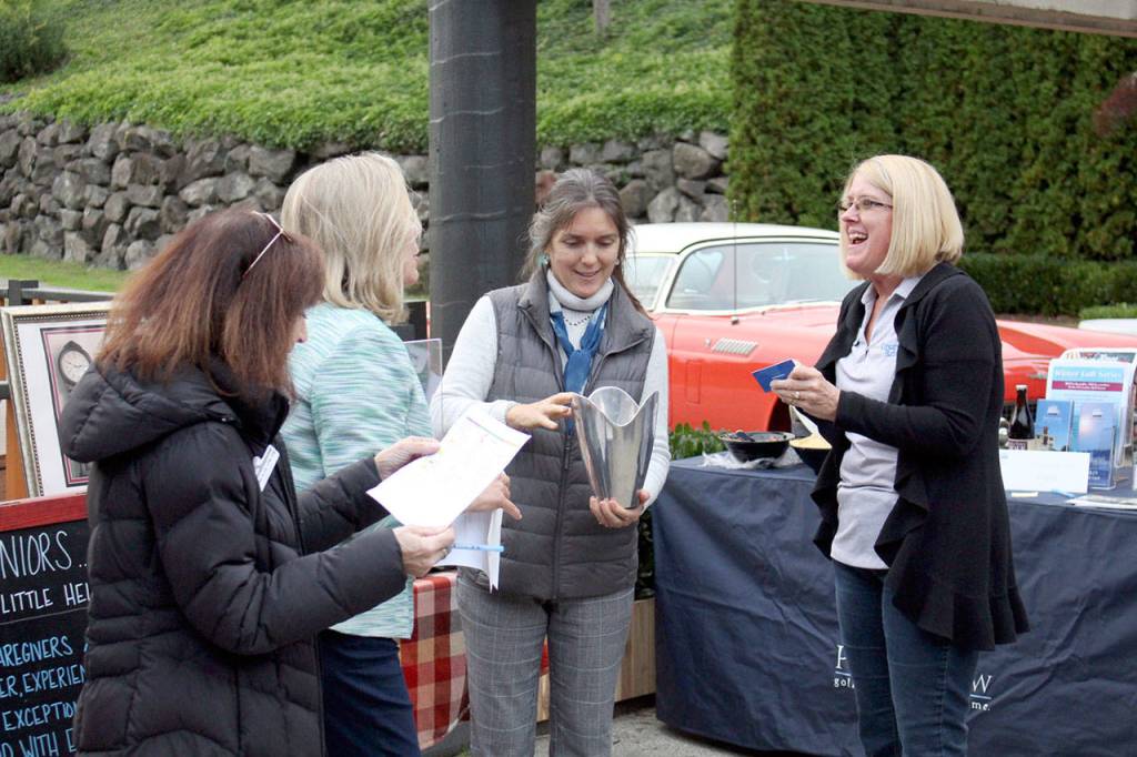 Jan Ralls of Kitsap Bank receives tickets to the Rose Theater in Port Townsend after her name was drawn during a raffle at the business expo. (Zach Jablonski/Peninsula Daily News)