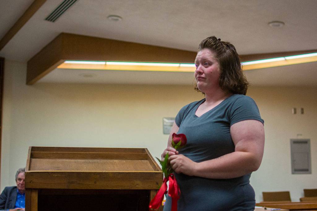 Sandra Schroeder holds a flower as friends and family congratulate her on graduating from drug court. (Jesse Major/Peninsula Daily News)