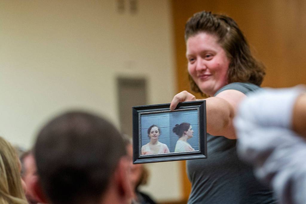 Sandra Schroeder, following drug court tradition, shares her mugshot with other drug court participants as she graduates. (Jesse Major/Peninsula Daily News)