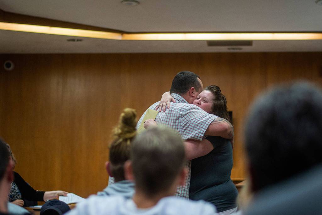 Jeffrey Haley, a counselor at Cedar Grove, embraces Sandra Schroeder as she graduates from drug court. (Jesse Major/Peninsula Daily News)
