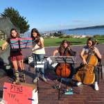 Port Townsend High School orchestra students Chloe Lampert, left, Magdaline Ferland, Adeline Gellert DePalma and Zoe Cook perform near Pope Marine Park on Water Street during the Port Townsend Film Festival to help raise money for their trip to Los Angeles. (Daniel Ferland)
