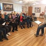 Joel Yelland directs the Interfaith Clallam County Peace Choir in a recent rehearsal.