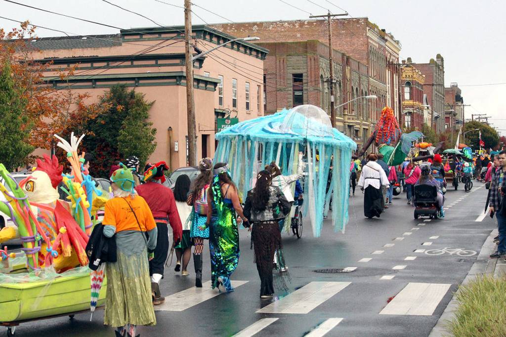 Kinetic Race participants and community members parade down Water Street on Saturday morning as the racers head for their break test and the water portion of the race. (Zach Jablonski/Peninsula Daily News)