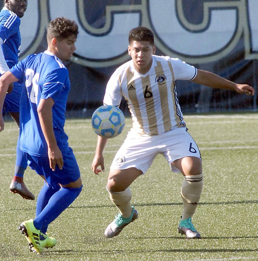 Keith Thorpe/Peninsula Daily News Edmonds Omar Padilla, left, and Peninsulas Manny Lopez-Morales eye a loose ball on Saturday in Port Angeles.
