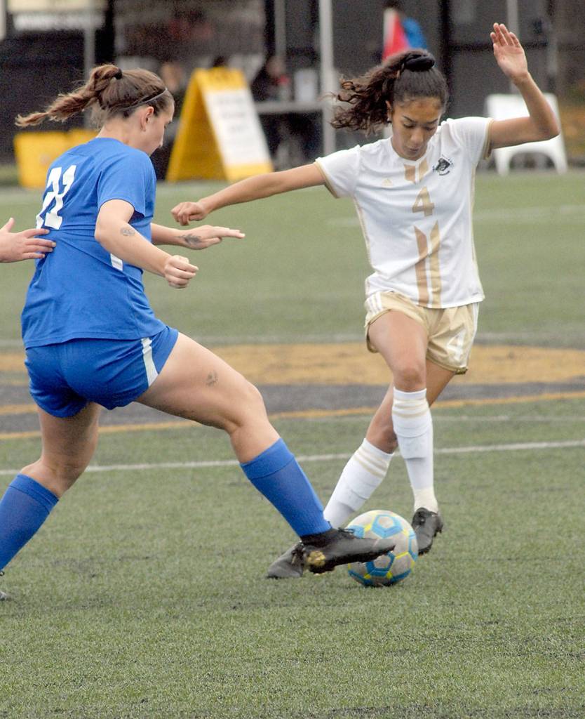Keith Thorpe/Peninsula Daily News Peninsulas Zahori Toledo, right, fends of the defense of Edmonds LeeAnn Sweider at Wally Sigmar Field on Saturday.