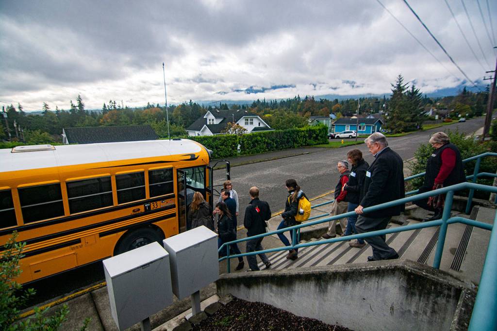 Community members load into a school bus before they tour Stevens Middle School in Port Angeles. (Jesse Major/Peninsula Daily News)