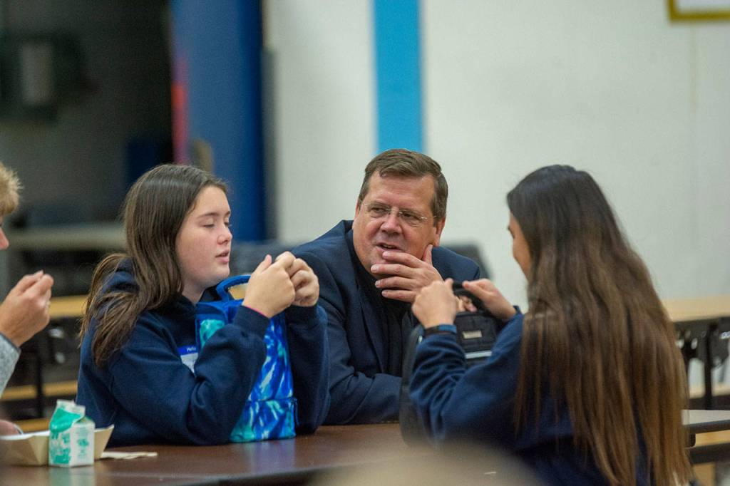 Marc Abshire, director of the Port Angeles Regional Chamber of Commerce, chats with students during lunch at Stevens Middle School. (Jesse Major/Peninsula Daily News)