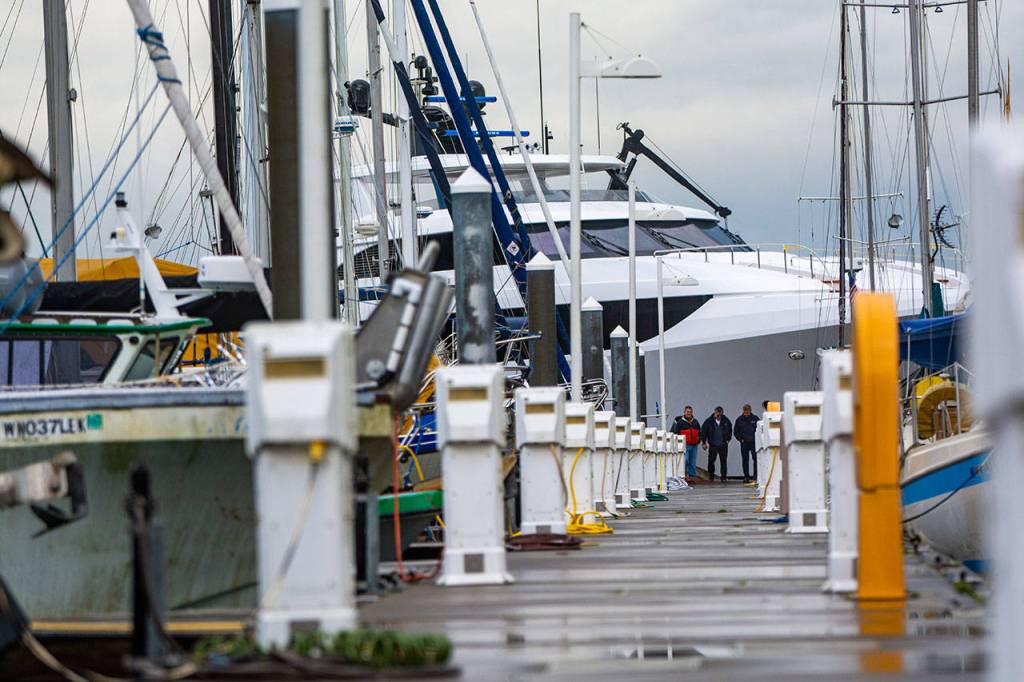 Officials from Westport look over damage after a Westport yacht smashed into docks at the Port Angeles Boat Haven on Monday morning. (Jesse Major/Peninsula Daily News)
