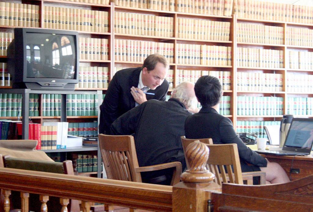 Defense attorney Jake Range, left, speaks with defendant Denver Shoop, 73, during Tuesdays proceedings in Jefferson County Superior Court. Shoop is facing a jury trial for the second time on animal cruelty charges based on the condition of eight bison that were seized from his Chimacum property in April 2018. (Brian McLean/Peninsula Daily News)