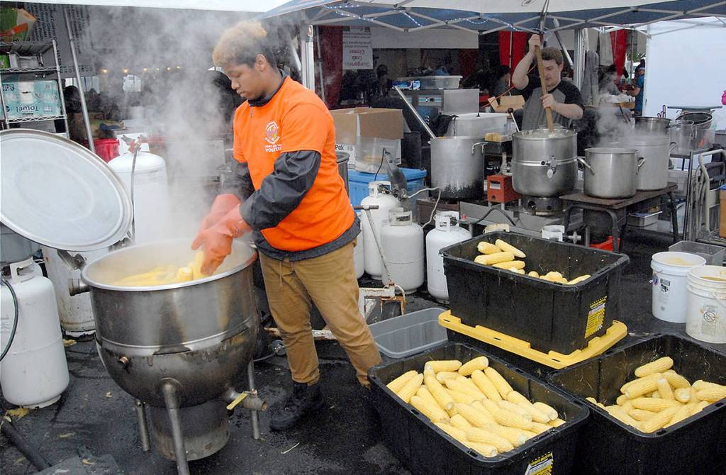 Volunteer corn cook Xavion Mason of Bakersfield, Calif., adds fresh ears to a boiler behind the scenes at the Dungeness Crab and Seafood Festival. (Keith Thorpe/Peninsula Daily News)