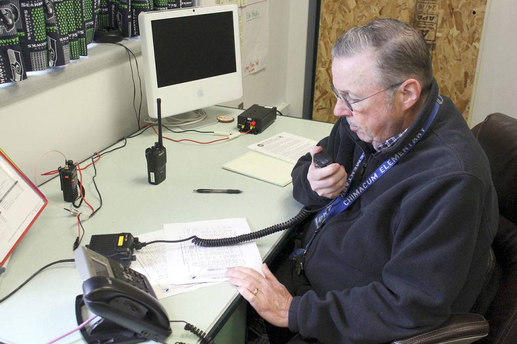 Chimacum Special Education teacher and amateur radio operator Jim Betteley gives a practice report to the Emergency Operation Center about the conditions at Chimacum School District during the Great ShakeOut drill Thursday. (Zach Jablonski/Peninsula Daily News)