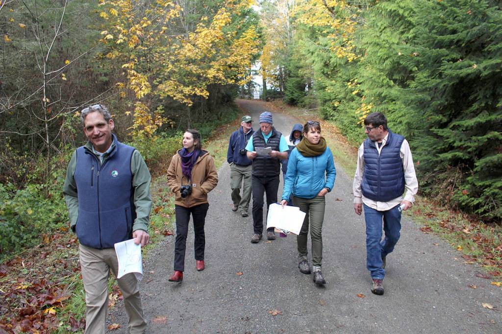 Matt Tyler, manager of Jefferson County Parks and Recreation, left, Libby Masaracchia of Jefferson County Public Works, along with Advisory Board members Tim Rensema, Vern Bessey, Marianne Walters, Malloree Weinheimer and Roger Hall walk toward the Silent Alder Loop Trail near Camp Beausite NW in Chimacum on Wednesday morning during an annual tour. (Zach Jablonski/Peninsula Daily News)