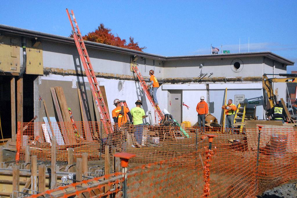 A construction crew works on a section of the existing pool building at the future Shore Aquatic Center in Port Angeles. (Keith Thorpe/Peninsula Daily News)
