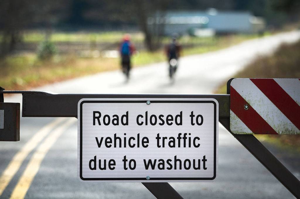 Two cyclists ride on Olympic Hot Springs Road, which is closed to vehicle traffic, on Sunday. (Jesse Major/Peninsula Daily News)