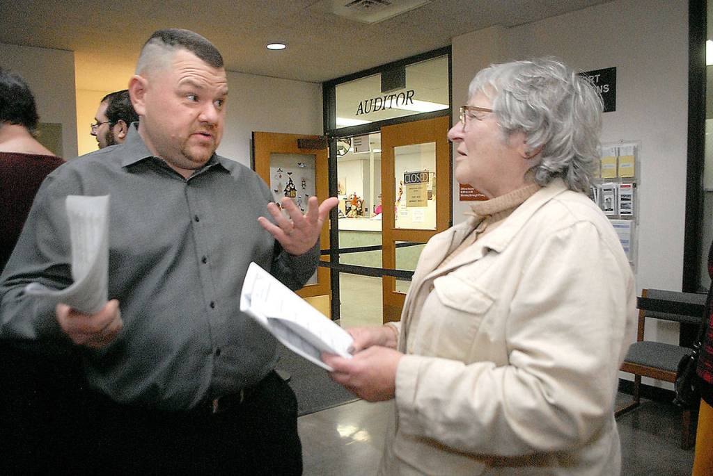 Sequim School Board candidate Eric Pickens, left, speaks with incumbent Olympic Medical Center Board Member Jean Hordyke in the lobby of the Clallam County Courthouse on Election Night in Port Angeles. (Keith Thorpe/Peninsula Daily News)