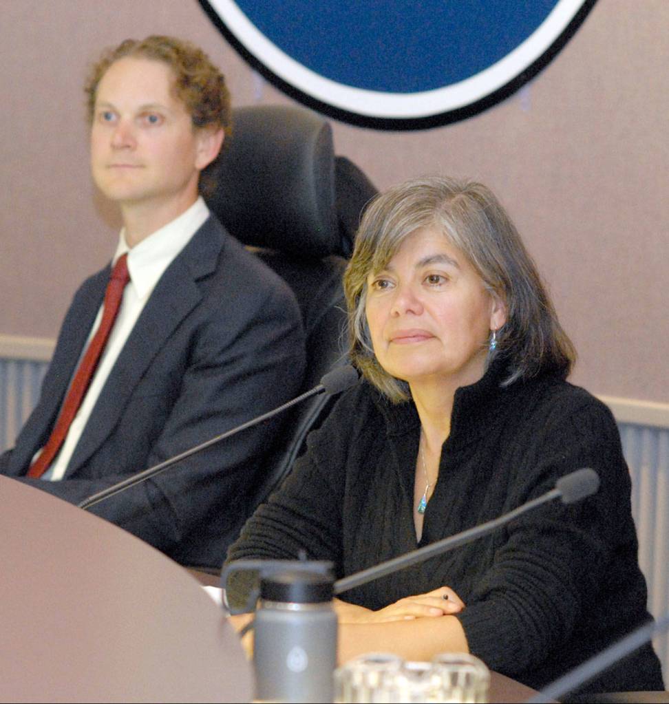 Port Angeles Mayor Sissi Bruch, front, and Council Member Lindsey Schromen-Wawrin listen to public comment about keeping the decorative silhouettes on a newly installed fence around the Liberty Bell replica in Veterans Memorial Park. (Keith Thorpe/Peninsula Daily News)