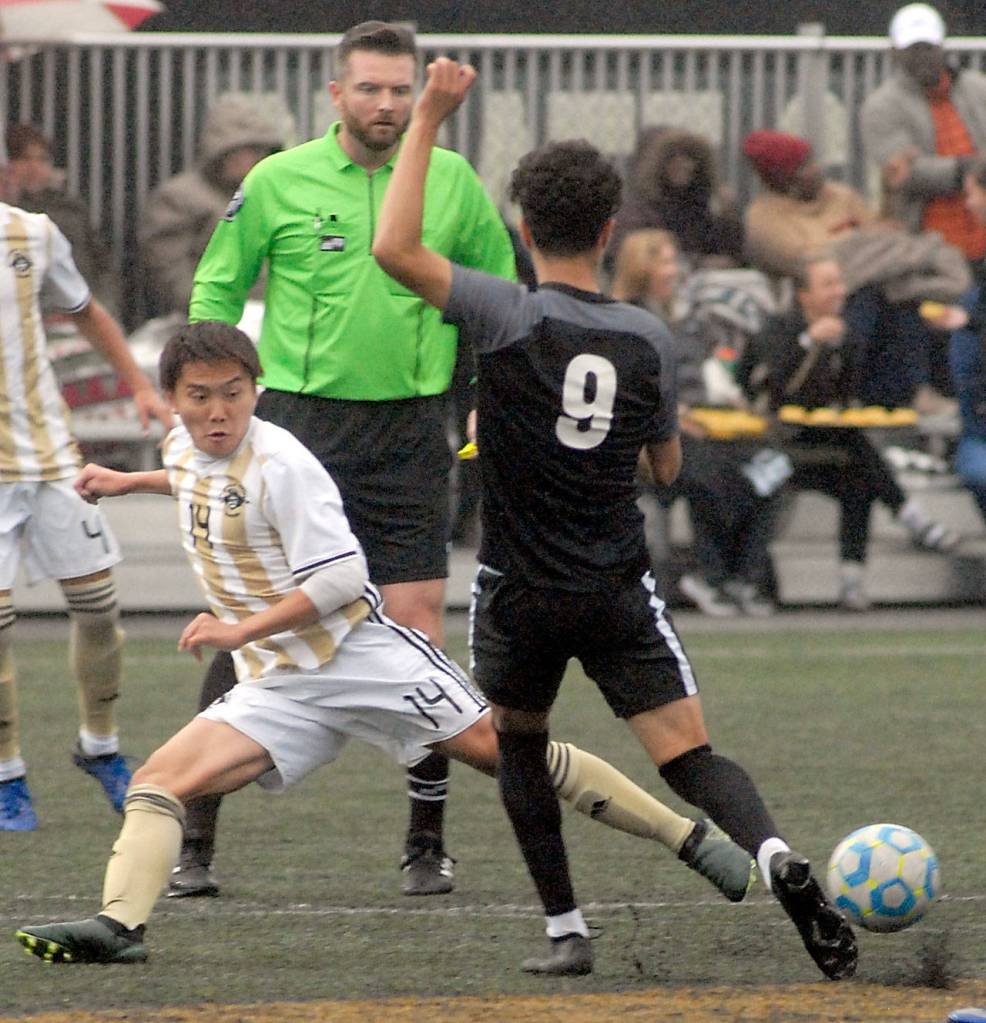 Peninsulas Kyota Hiate, left, makes a sliding tackle on Wenatchee Valleys Sergio Bravo during Saturdays quarter-final game. (Keith Thorpe/Peninsula Daily News)