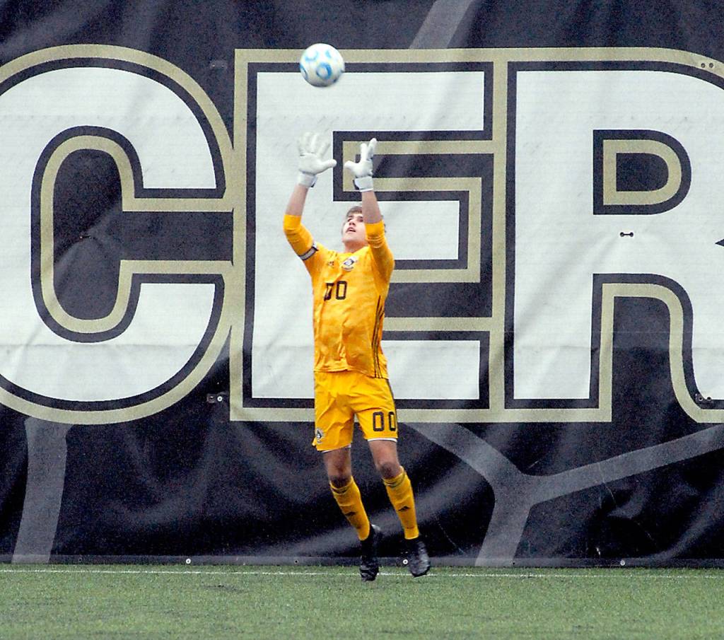 Peninsula goalkeeper Evan Scholes makes leaping catch on an incoming shot Saturday. (Keith Thorpe/Peninsula Daily News)