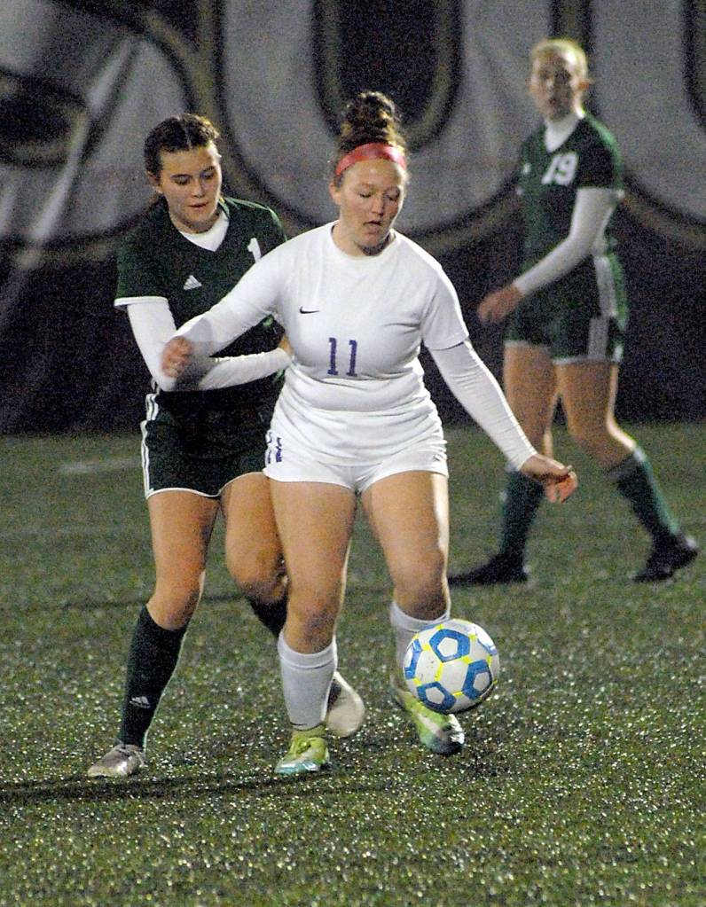 Sequims Alexis Smith, front, fends off Port Angeles Bailee Larson as Larsons teammate Isabella Money looks on during Saturday nights playoff match at Peninsula College in Port Angeles. (Keith Thorpe/Peninsula Daily News)