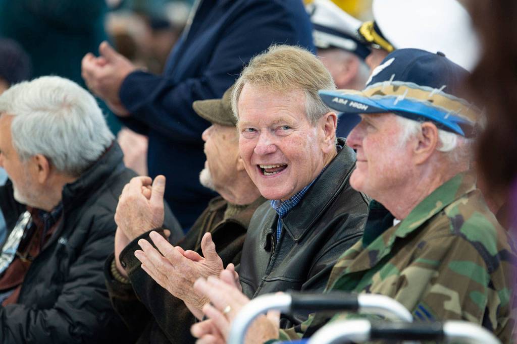Clallam County Commissioner Randy Johnson applauds as veterans are recognized during the Veterans Day ceremony at U.S. Coast Guard Air Station/Sector Field Office Port Angeles on Monday. (Jesse Major/Peninsula Daily News)