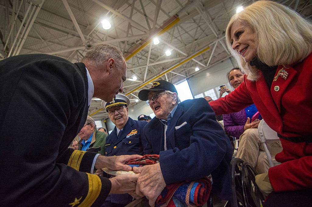 Rear Adm. Christopher Scotty Gray of the U.S. Navy reprents World War II veteran William Payne, of the Merchant Marine, with a quilt during the Veterans Day ceremony at U.S. Coast Guard Air Station/Sector Field Office Port Angeles on Monday. (Jesse Major/Peninsula Daily News)