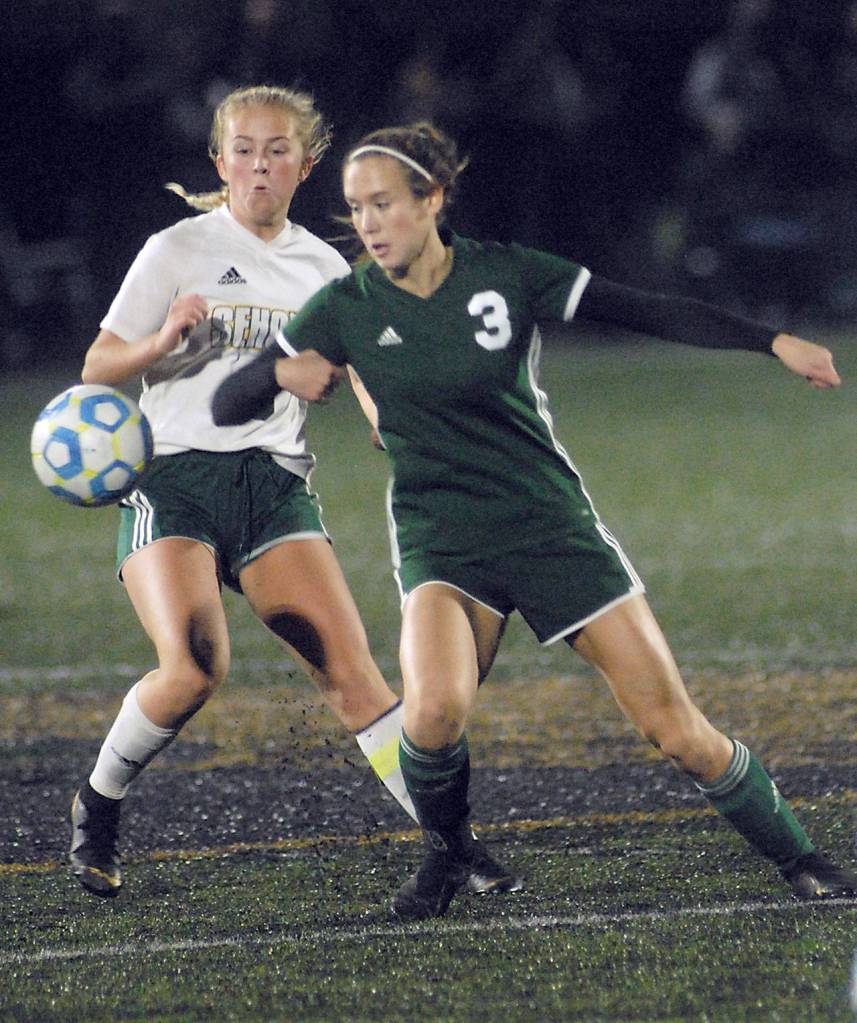 Port Angeles Hannah Reetz, right, eyes a loose ball as Sehomes Lillian Gruman looks on during Tuesday nights playoff match in Port Angeles. (Keith Thorpe/Peninsula Daily News)