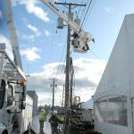 Port Angeles public utility workers install a metered power supply to the ice village. (Keith Thorpe/Peninsula Daily News)