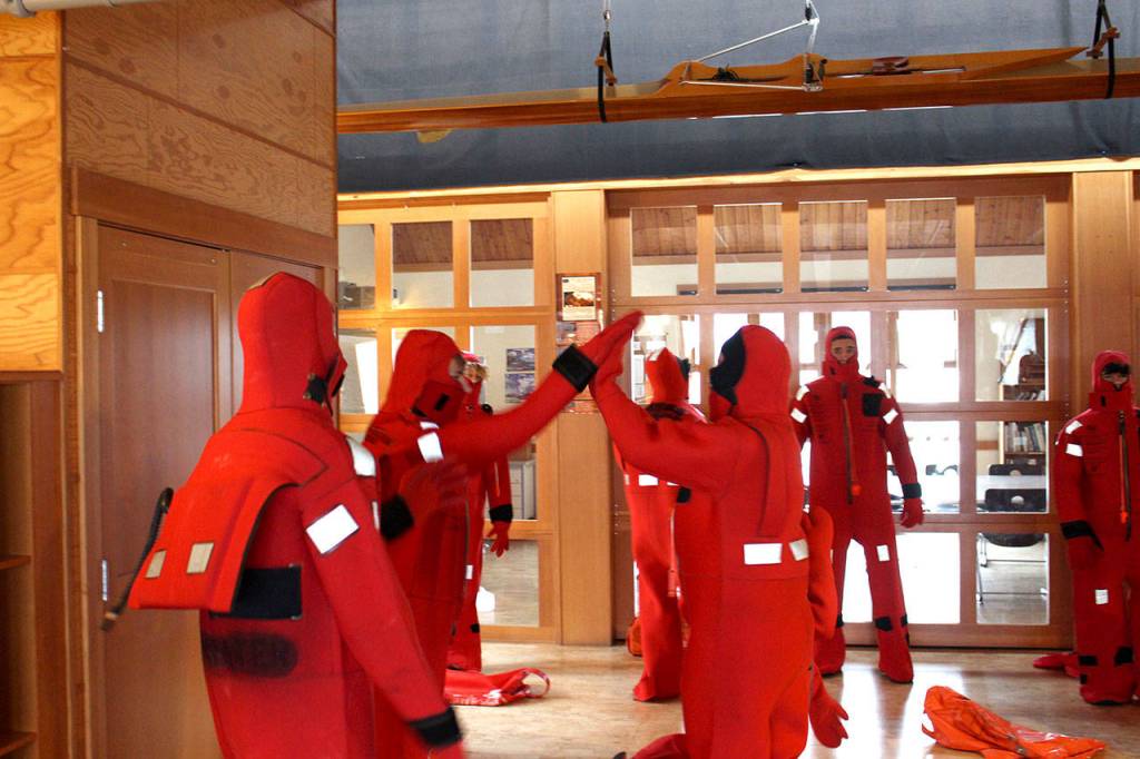 Maritime Academy Skills Center students celebrate after completing an exercise to put on their immersion suits within 60 seconds at the Port Townsend Maritime Center. (Zach Jablonski/Peninsula Daily News)