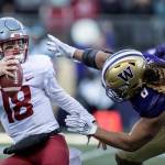 Washington State quarterback Anthony Gordon tries to escape the grasp of Washington defensive lineman Benning Potoae during the first half an NCAA college football game, on Friday, Nov. 29, 2019 in Seattle. (AP Photo/Stephen Brashear)