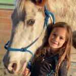 Daniella Damm, 7, with Snickers, is a beginning Hoof Beats student at Freedom Farm. When not riding, she enjoys practicing her ground work, such as trotting side-by-side through obstacles and enhancing her horse communication skills with farm co-owner Mary Gallaghers mini-horse Comet. (Mary Tulin)