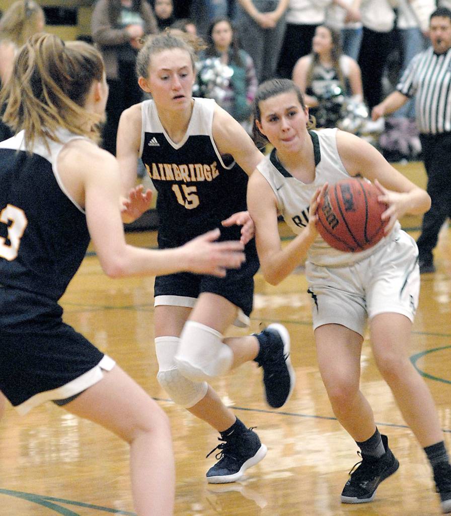Port Angeles Bailee Larson, right, looks to pass as Bainbridges Ellie Woolever, left, and Olivia Wikstrom close in on defense on Tuesday night on the Roughrider home court. (Keith Thorpe/Peninsula Daily News)