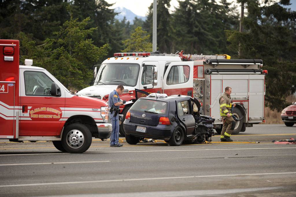 A firefighter and a police officer assess damages of the collision. (Michael Dashiell/Olympic Peninsula News Group)