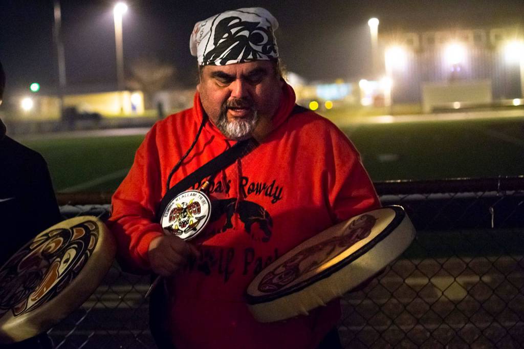 Mark Charles of the Lower Elwha Klallam Tribe leads a song during the vigil for Tristen Pisani at Spartan Stadium in Forks on Thursday. (Jesse Major/Peninsula Daily News)
