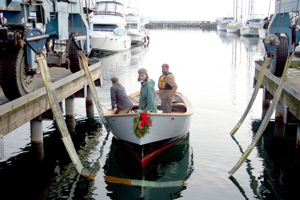 From left, Bill Billingsley, Demian Detweiler and Jody Boyle stand in the Orca, an 18-foot Gartside workboat, as its launched Monday at the Point Hudson Marina in Port Townsend. (Brian McLean/Peninsula Daily News)