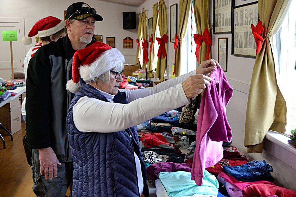 Bryan Adair of Sequim looks for clothes for his four children ages 1-15 with help from Nancy Garbush. Adair said it was his second time attending Toys for Sequim Kids and that its the most fantastic thing. (Matthew Nash/Olympic Peninsula News Group)
