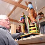 Drew Elicker shows some of the 36-inch standing figures hes created of people performing everyday tasks. (Brian McLean/Peninsula Daily News)