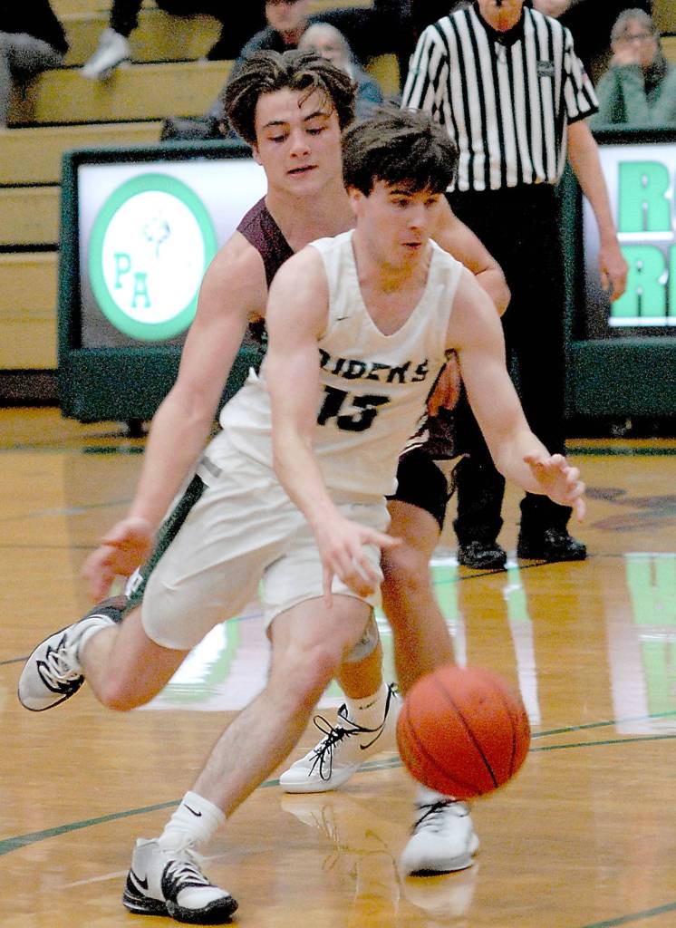 Port Angeles Stuart Methner, front, slips around the defense of Lakewoods Jared Taylor during Saturday nights game in Port Angeles. (Keith Thorpe/Peninsula Daily News)