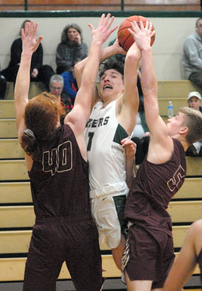 Port Angeles Gary Johnson, center, is surrounded by Lakewoods Andrew Molloy, left, and Shae Dixon as he shoots for the hoop on Saturday in Port Angeles. (Keith Thorpe/Peninsula Daily News)