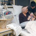 Olympic Medical Center Foundation presented a gift basket filled with infant care items, along with a commemorative towel, to the Lee Family on Wednesday. (Keith Thorpe/Peninsula Daily News)