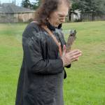 Jasmine Hunt, who lives near Lions Park in Port Angeles, holds a bundle of burning sage on Friday as she marks the one-year annniversary of the felling of a controversial sequoia tree that once towered over the neighborhood. (Keith Thorpe/Peninsula Daily News)