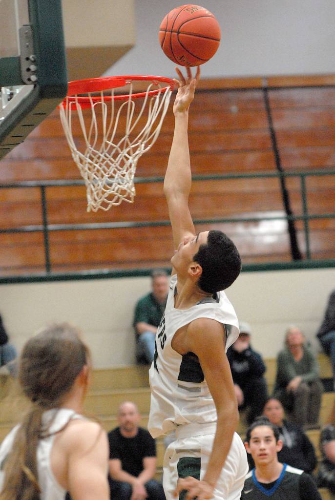 Port Angeles Damen Ringgold goes for a layup as teammate Derek Bowechop, left, looks on during Friday nights game against Olympic in Port Angeles. (Keith Thorpe/Peninsula Daily News)