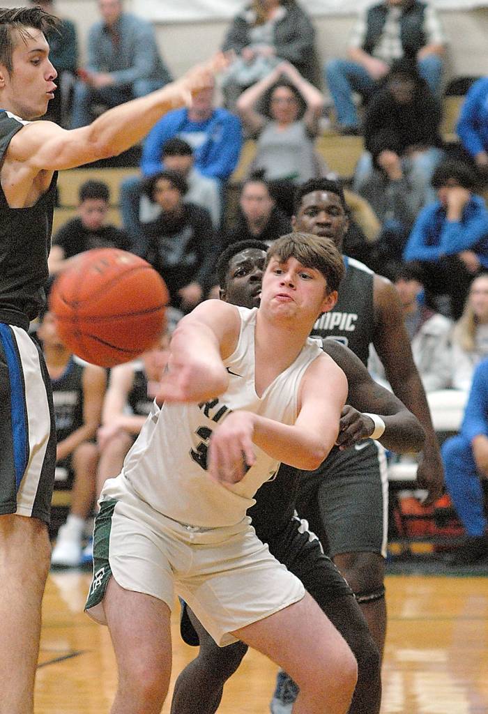 Port Angeles Wyatt Dunning, center, makes a pass as Olympic defenders, from left, Cadyn Kinsfather, Malcom DeWalt and Kendall McInnis at Port Angeles Highs School on Tuesday. (Keith Thorpe/Peninsula Daily News)